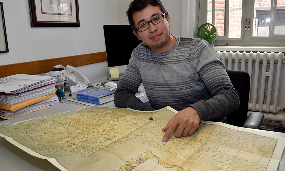 巴勃罗·塞拉在他的办公室里，指着地图