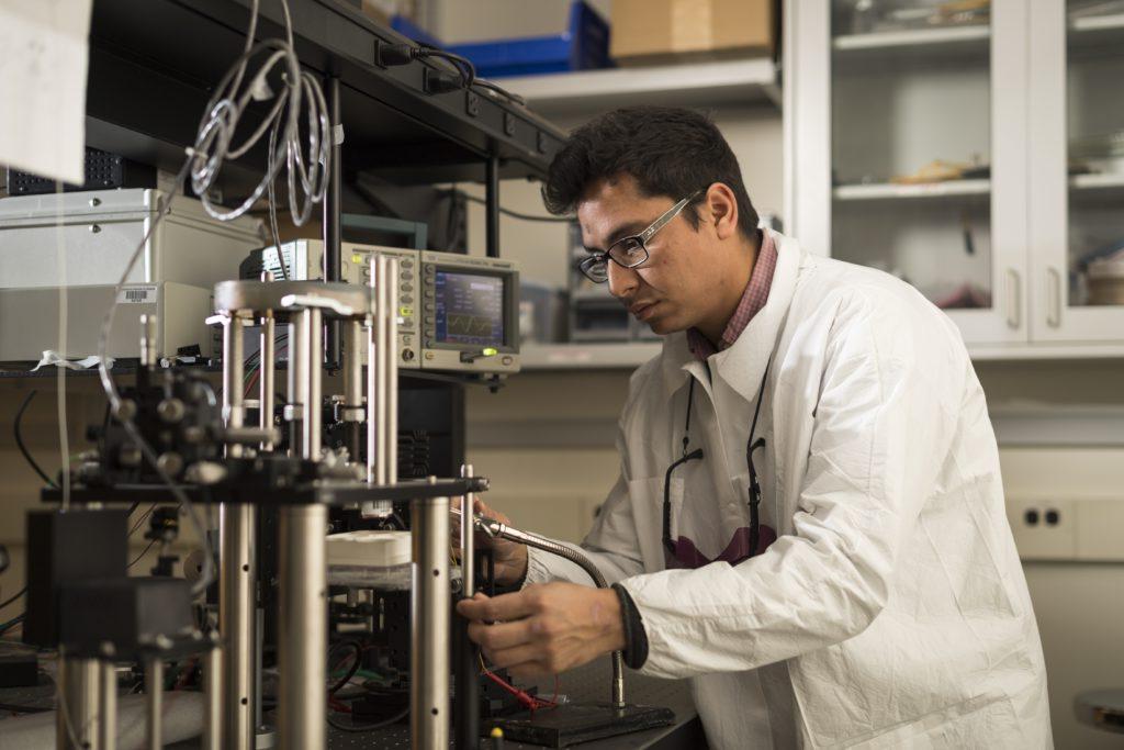 A University of Rochester student in a laboratory tinkering with metal equipment